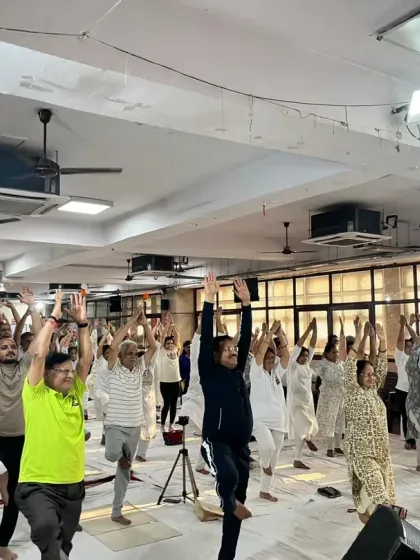 A large group of participants joyfully practicing Tree Pose (Vrikshasana) during our International Yoga Day event at Shree Balaji Mandir.