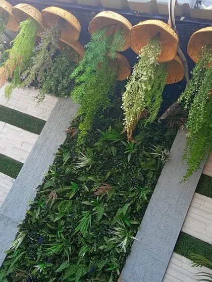 Another angle of the unique hanging hat planters, showing how they are arranged against a green wall.