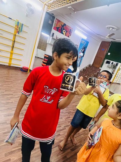 A student proudly holding up his branded mug. It's great to see them so happy with their achievements in class.