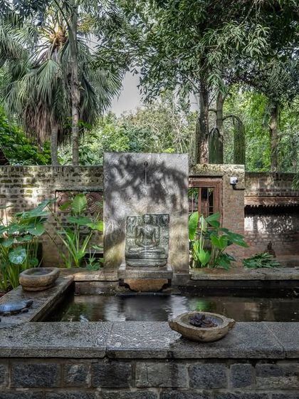A quiet corner featuring a small, traditional pond and stone fountain, showcasing the peaceful, contemplative spots scattered throughout our property.