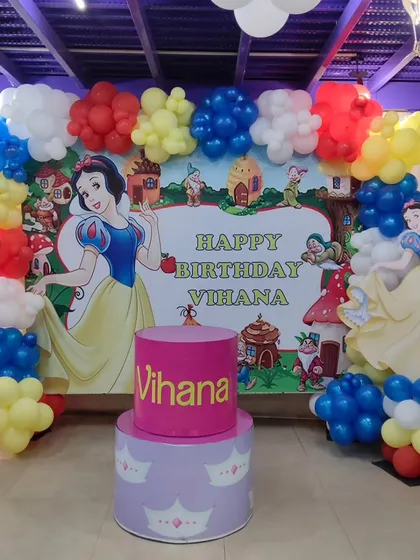 A fairy tale comes to life with this Snow White and the Seven Dwarfs birthday theme. The colorful balloon arrangement and character backdrop create a magical setting.
