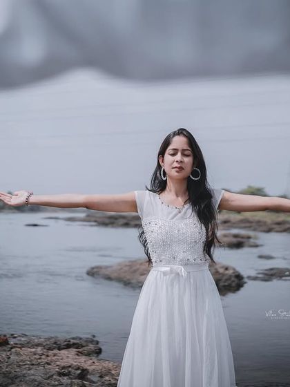 A close-up of the bride-to-be in a free-spirited pose. The focus is entirely on her serene expression and the beautiful natural setting.