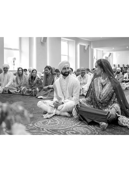 Shaan and Shubham share a look during their Anand Karaj ceremony. The quiet reverence of the Gurudwara, combined with their infectious excitement, creates a deeply spiritual and joyful atmosphere.