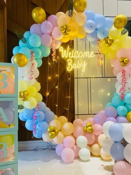 A beautiful pastel rainbow balloon ring for a "Welcome Baby" celebration. This decoration features a neon sign and "BABY" blocks, creating a soft and dreamy atmosphere.