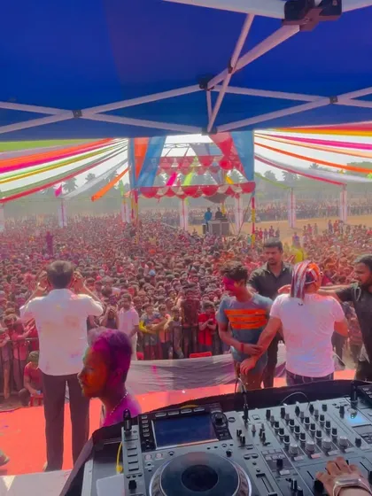 The view from behind my Pioneer DJ setup at the Banhatti Holi festival. You can see the massive scale of the crowd, stretching far back under the colorful decorations.