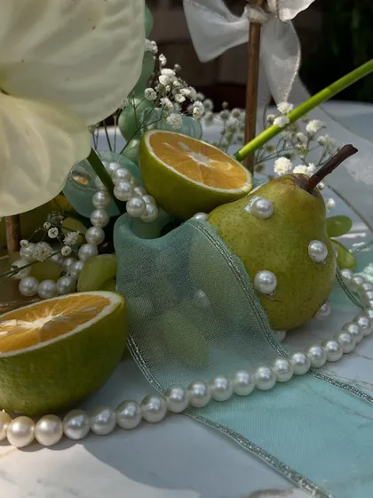 A detailed shot of a table centerpiece, where we incorporated fresh fruit and delicate pearls for a touch of unique elegance.