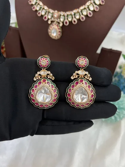 The 'Amaya' premium moissanite kundan earrings, featuring a large polki stone with red meenakari.