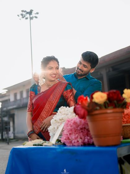 A sweet moment captured over a flower stall. The bright sun flare and colorful flowers add a cheerful and romantic vibe to this city photoshoot.