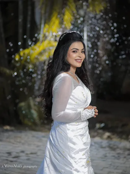 A full-length shot of a model in a beautiful white gown, showcasing a classic Christian wedding look with long, flowing hair.