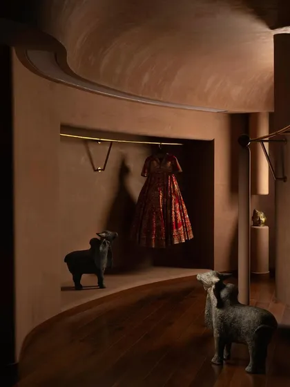 The space is a journey through a series of reveals and enclosures. Here, animal sculptures stand guard along a winding path, adding a touch of playful surrealism.