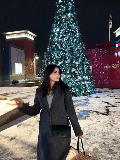 A festive shot in front of a large Christmas tree at the Toronto Premium Outlets, capturing the holiday spirit.