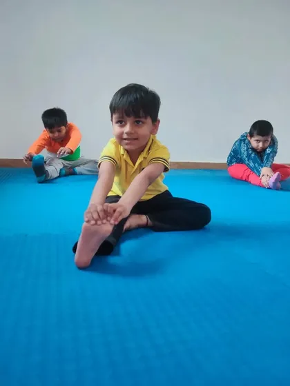 A young student in our Taekwon-Do class demonstrates a seated stretch. We pay close attention to the physical development of each child.