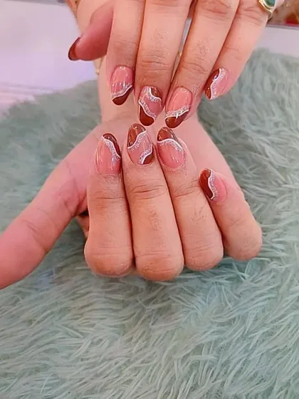 A beautiful abstract design with a sheer brown base and delicate white and silver glitter swirls.
