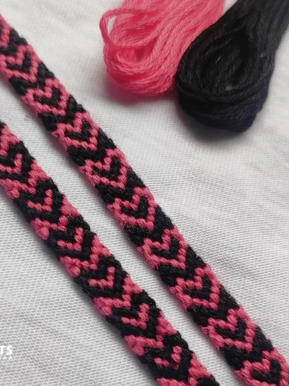 A close-up of the pink and black heart-chevron bracelets next to the threads they were made from.