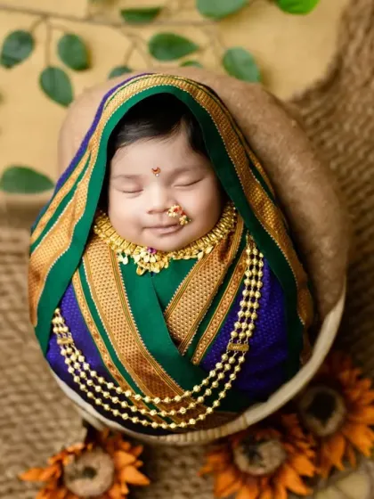 A sweet, smiling newborn in our traditional Maharashtrian setup.