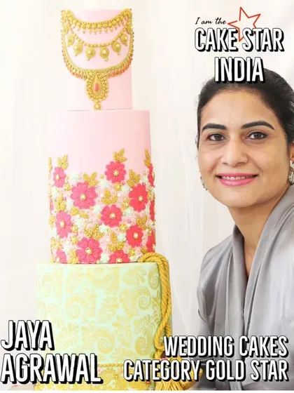 I am pictured here with my award-winning wedding cake design that earned a Gold Star from Cake Star India. This multi-tiered cake features intricate floral patterns and a stunning edible gold jewelry piece, showcasing my skills in creating high-end celebration cakes.