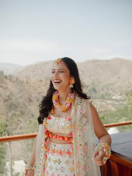 The pure joy of a Haldi ceremony. This bride's makeup is fresh and dewy, with a natural finish that lets her infectious laugh be the main focus.