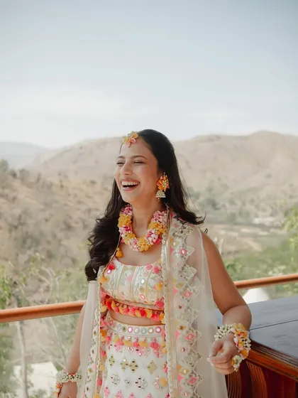 The pure joy of a Haldi ceremony. This bride's makeup is fresh and dewy, with a natural finish that lets her infectious laugh be the main focus.