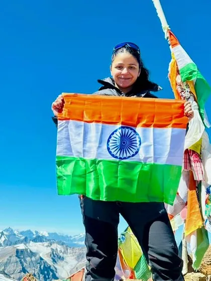 A trekker holding the Indian flag at the summit of Yunam Peak. A feeling of immense pride and accomplishment.