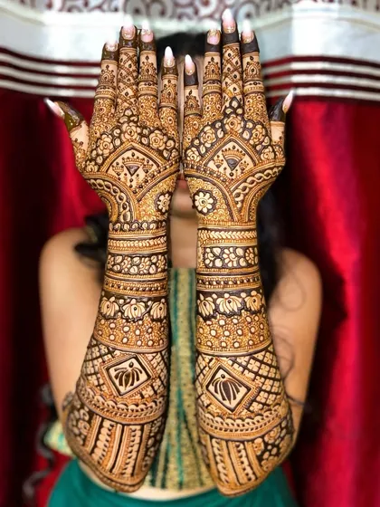 This is a full-coverage bridal mehandi that extends up to the elbows. The design features a beautiful mix of floral patterns, lotus motifs, and geometric jaal work for a classic and elegant look.