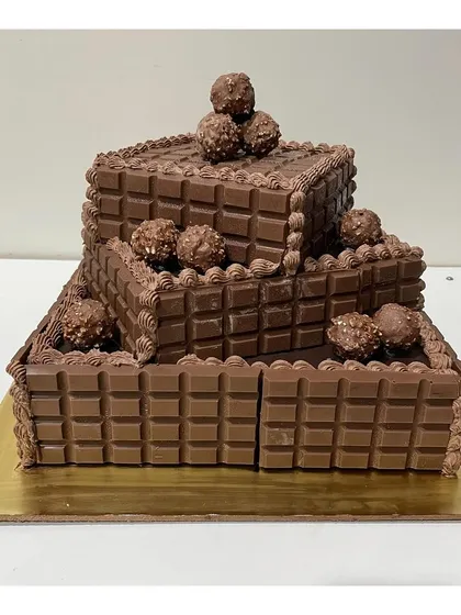 A top-down view of the decadent 3-tier square chocolate cake, showcasing the arrangement of Ferrero Rocher on each level.