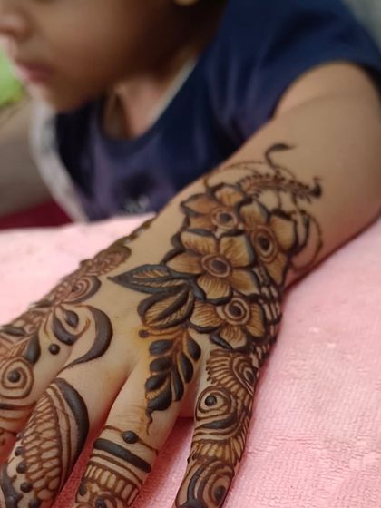 Another angle of this beautiful floral piece. The design features a cluster of flowers at the wrist and trails elegantly down the fingers, a classic and timeless mehendi style for children.
