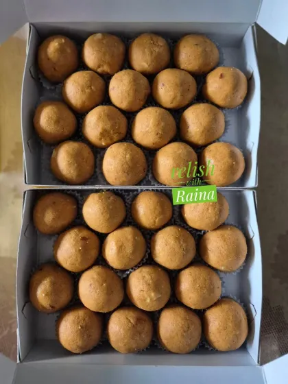 Two boxes of freshly made Besan Laddoos. The slow-roasting process in pure ghee gives them their signature flavor and aroma.