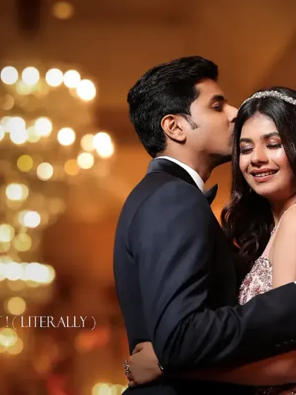 A sweet and romantic moment with a beautiful bokeh background. The groom's gentle kiss on the forehead is a classic expression of love.