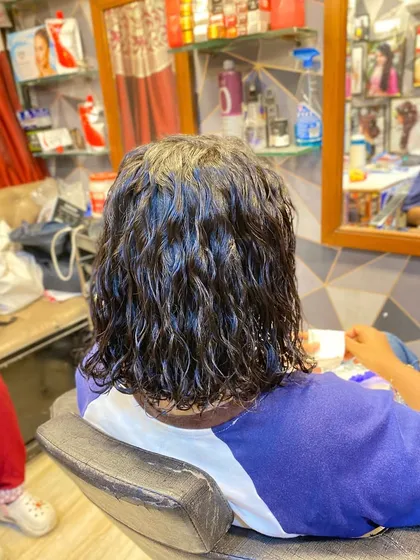 The final result after the perming process is complete and the rods are removed. The hair now has a consistent, beautiful wave pattern.