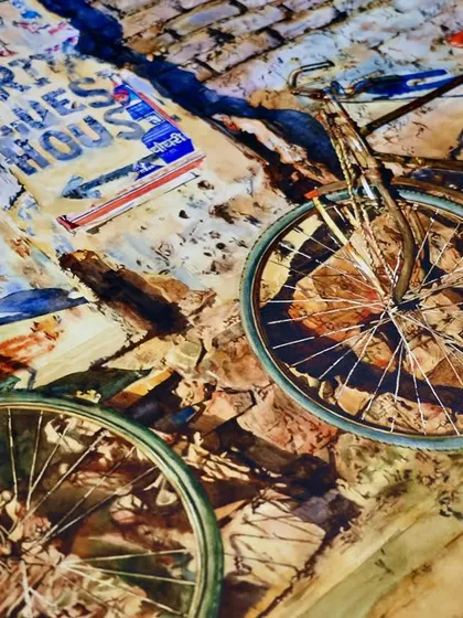 A close-up of the two-bicycle painting, focusing on the details of the wheels and the texture of the brick wall.