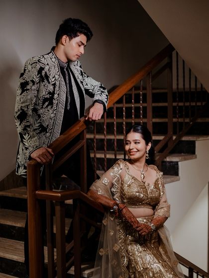 An elegant portrait of the couple on a staircase, exuding classic charm and romance during their Sangeet night.