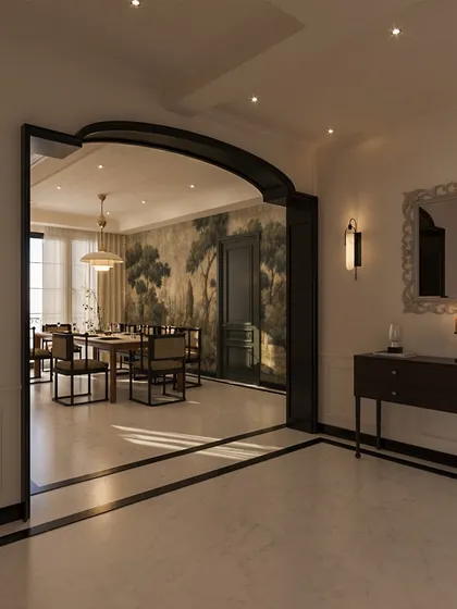 An arched, dark-trimmed opening creates a beautiful frame for the dining room beyond. This technique allows for a sense of separation while maintaining a visual connection, highlighting the statement wallpaper and elegant setting within.