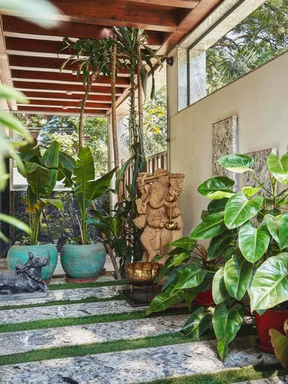 A client's lush entryway featuring our standing Ganesha statue. Paired with our antique sea green planters, it creates a welcoming space that blends spiritual art with natural beauty.