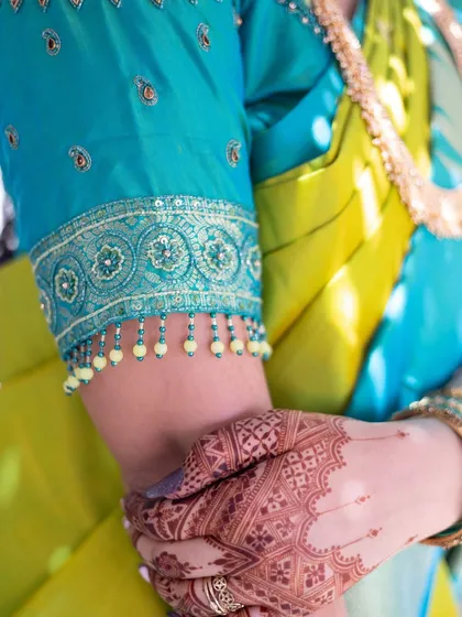 A glimpse of the beautiful stain on the back of the hand, complementing the bride's traditional blue and green saree.