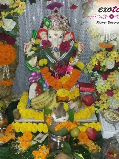A traditional home Ganpati pooja setup, complete with offerings of fruits, a sacred kalash, and simple garlands of marigold flowers. We ensure every element of the decoration is arranged with care and respect for tradition.