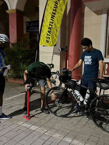 A volunteer from our Start Line Support team helps a rider with a final tire pump. This service gives participants peace of mind as they begin their long journey.
