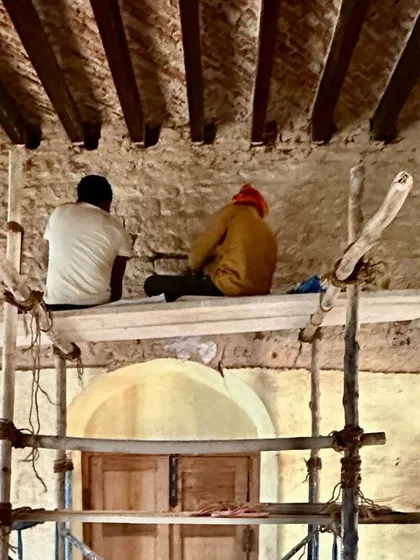 A repeat image of workers on the scaffold, reinforcing the theme of focused, collaborative craftsmanship.