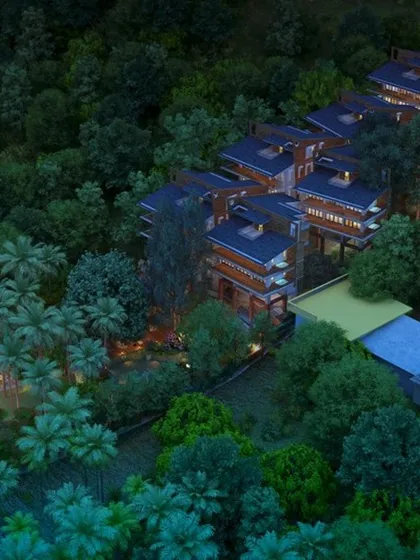 An aerial view of the Atmanya boutique resort in Goa at dusk, a design that harmonizes with its lush, waterfront landscape to create a tranquil and immersive natural retreat.