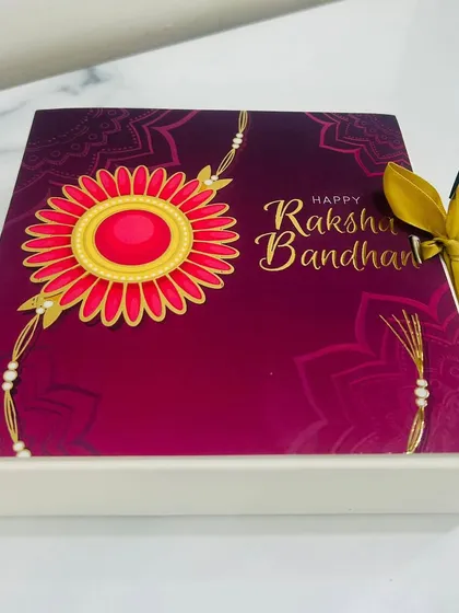 The beautiful Rakhi-themed packaging I use for my gift boxes. This sleeve with a floral rakhi design adds a special festive touch to your present.