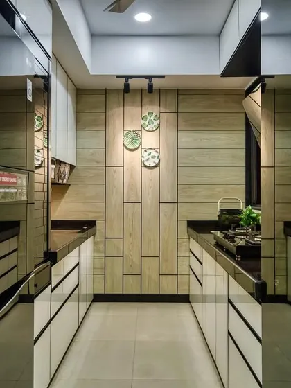 A reflection shot of the Lodha Park kitchen, highlighting the glossy surfaces and smart track lighting.