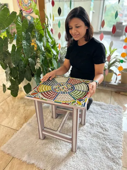 Here is the completed mosaic stool. The colorful tiles create a unique, eye-catching pattern, turning a forgotten piece into a functional piece of art.