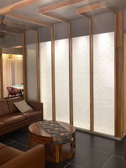 In this Lucknow penthouse, we used custom 'lantern' partitions to divide an open-plan living area. These fixtures integrate local Chikankari craft into backlit panels, creating soft, patterned light that defines the space and serves as a unique architectural feature.