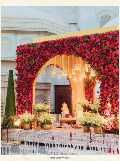 A close-up of the magnificent floating mandap, framed by a wall of red roses and accented with hanging lights, creating a breathtaking focal point for the ceremony.