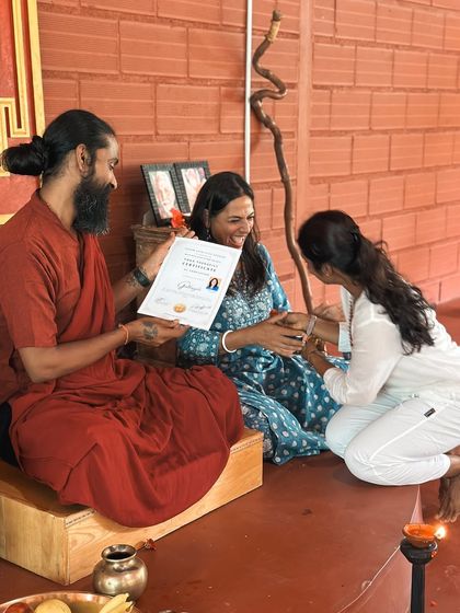 A graduate receives her certificate, her face beaming with joy. This moment marks not an end, but the beginning of a new chapter as a confident and knowledgeable yoga teacher.