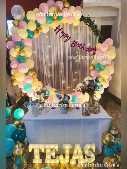 A pastel-colored balloon ring in front of a fairy light curtain, perfect for a soft and dreamy theme.