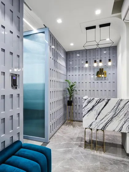 A first impression matters. This reception area for the 'Greywood Loft' project was designed to be unforgettable, featuring a statement marble desk, custom geometric wall paneling, and dramatic pendant lighting.