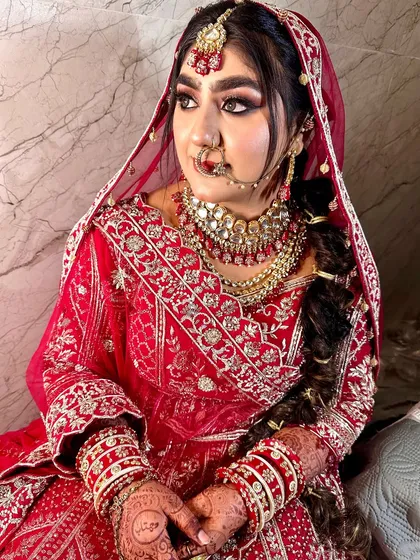A breathtakingly beautiful bride. This look features dramatic eye makeup and a traditional braided hairstyle, perfect for a Punjabi or Rajasthani-inspired wedding.