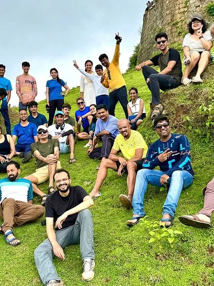 A group of friends posing on a grassy hill, relaxed and happy. Our treks are about creating a comfortable and friendly environment for everyone.