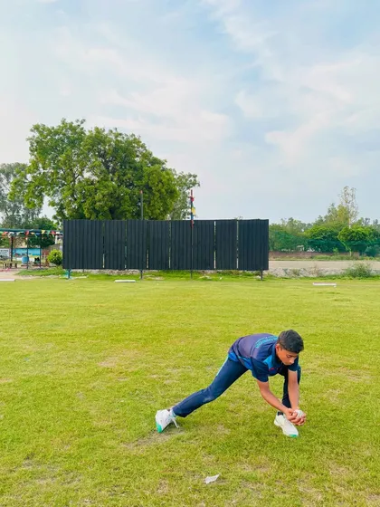 A player demonstrating the correct low posture for fielding. Being low to the ground is key for quick movement and clean pickups.