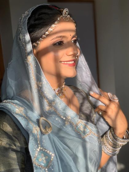 A sun-kissed shot of a bride during her Path function. The light blue outfit and minimal makeup create a fresh and serene look for a daytime ceremony.